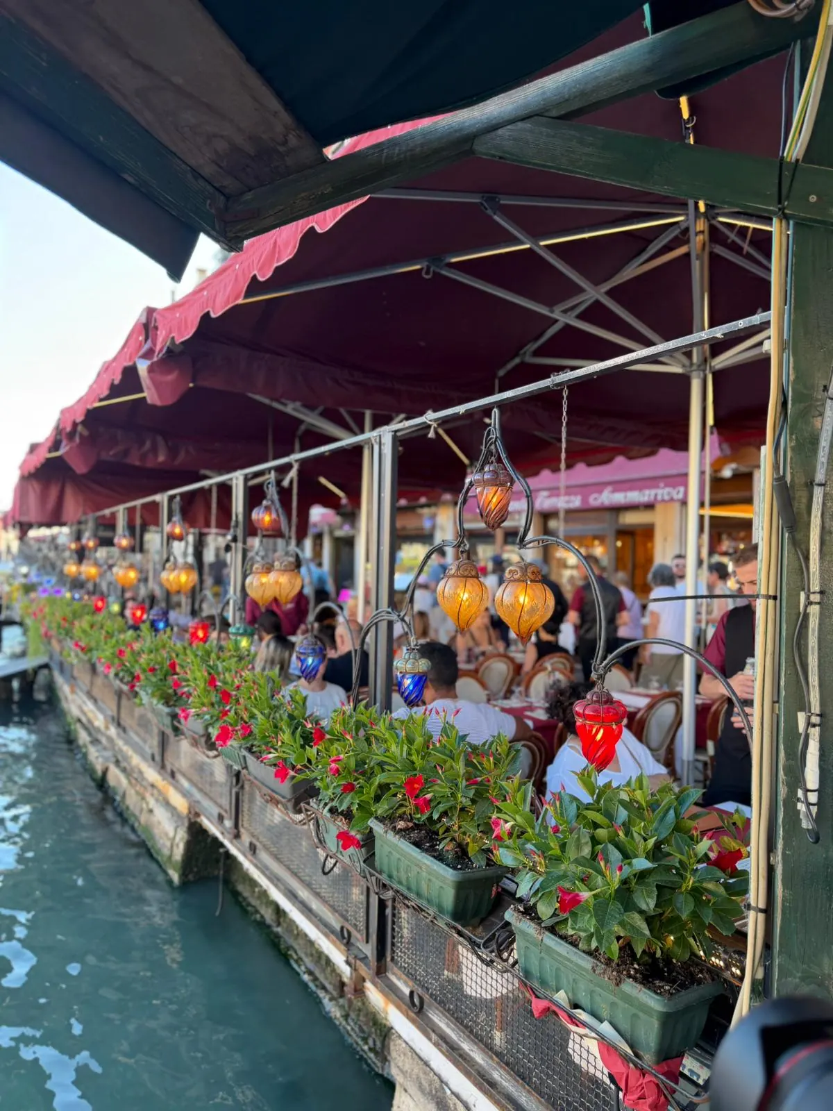 Colored Murano glass lanterns and flowers above the Grand Canal